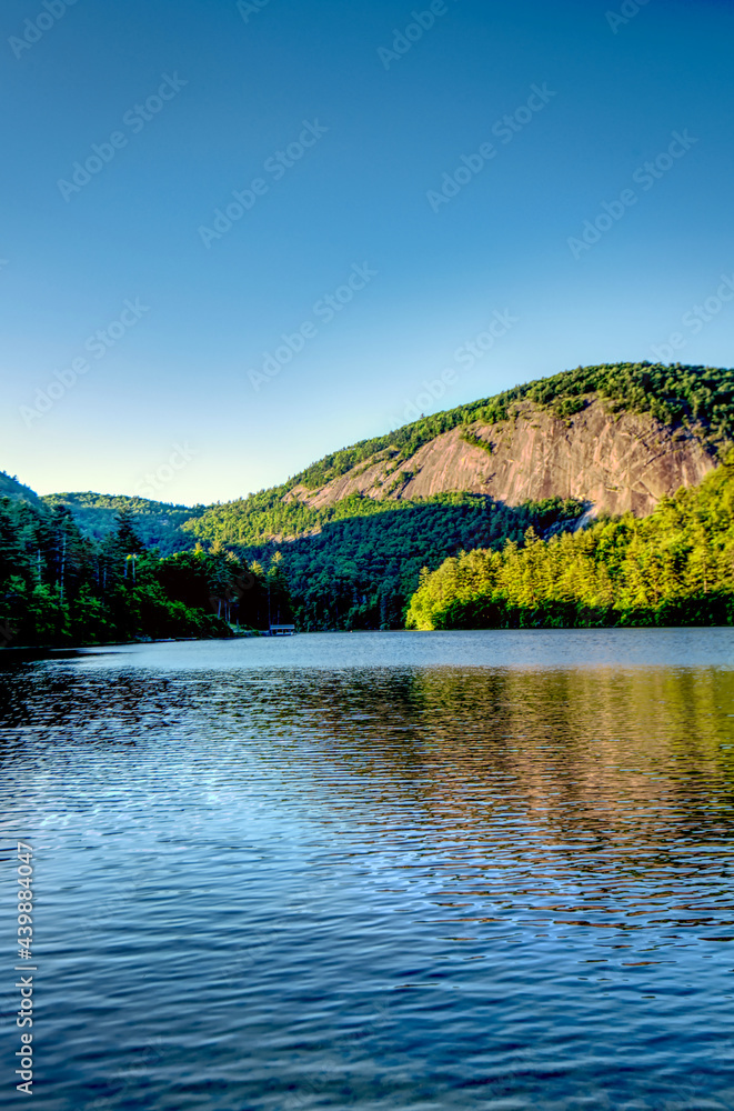 A beautiful mountain lake with a rock monolith mountain in the background.