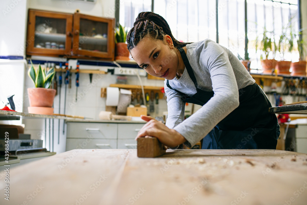 Female carpenter working with plane in workshop Female carpenter working with plane in workshop