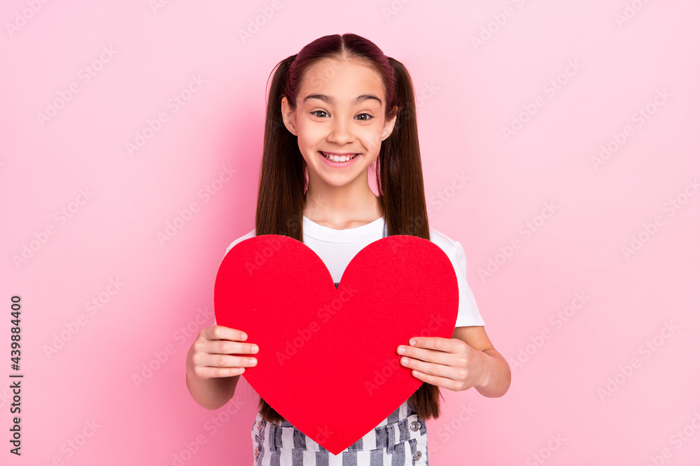 Photo of attractive cure young little girl hold hands heart shape good mood love isolated on pink color background Photo of attractive cure young little girl hold hands heart shape good mood love isolated on pink color background