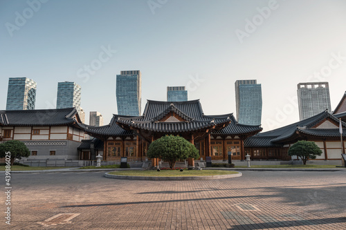 Traditional wooden korean architecture luxury Gyeongwonjae Ambassador hotel building with skyscraper in central park at Songdo