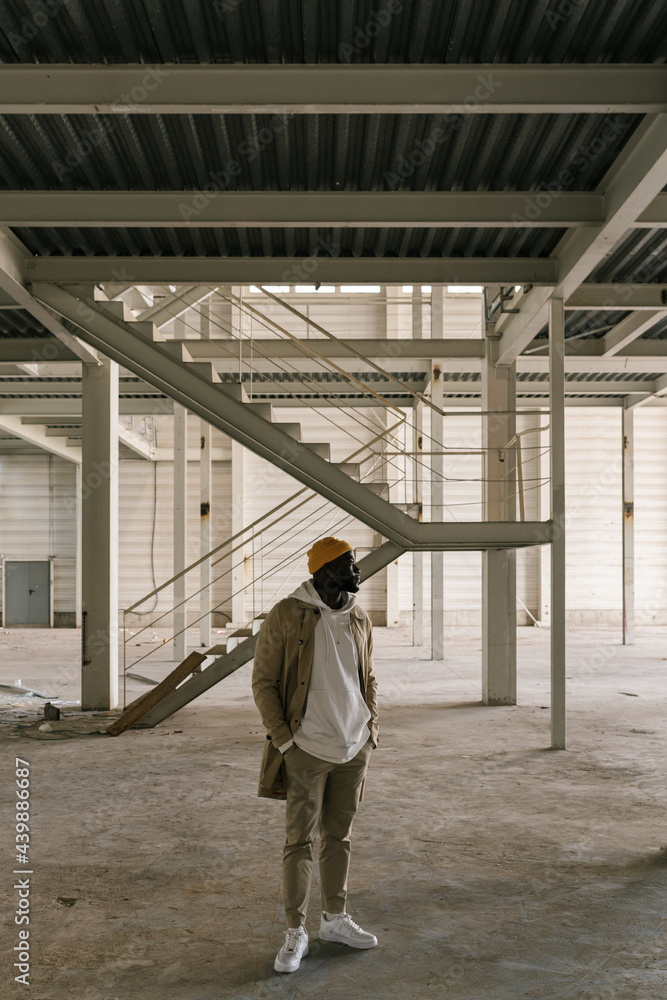 Black man standing with relaxed pose in an industrial compound. Black man standing with relaxed pose in an industrial compound.