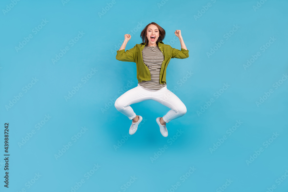 Full size photo of cheerful happy young woman winner lucky lady celebrate isolated on blue color background Full size photo of cheerful happy young woman winner lucky lady celebrate isolated on blue color background