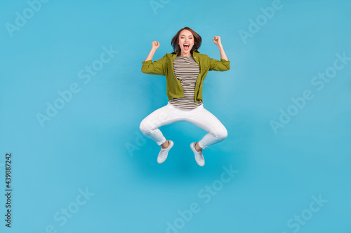 Full size photo of cheerful happy young woman winner lucky lady celebrate isolated on blue color background