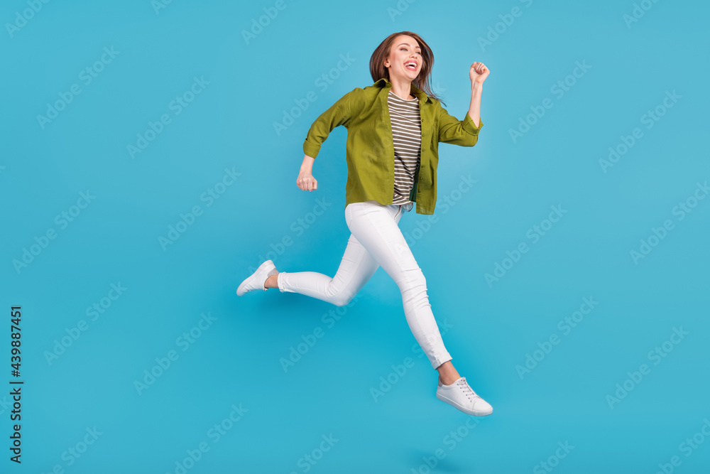 Full body photo of charming happy nice woman jump up run empty space isolated on blue color background