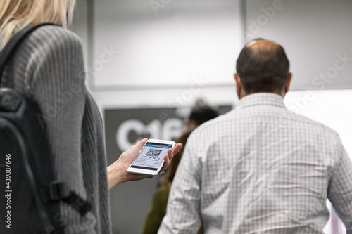 Travel: Woman Checks Flight Info While Waiting In Line At Gate