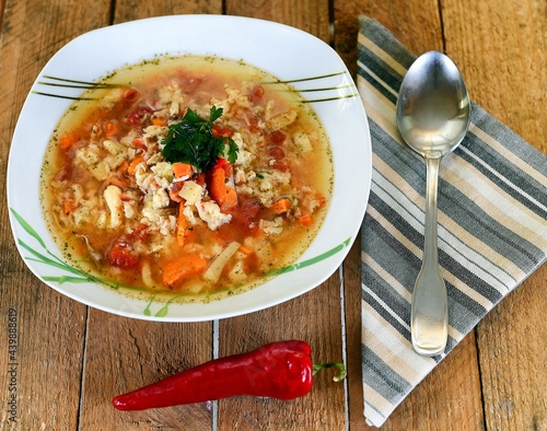 Vegetable soup on a plate on the wooden table photo