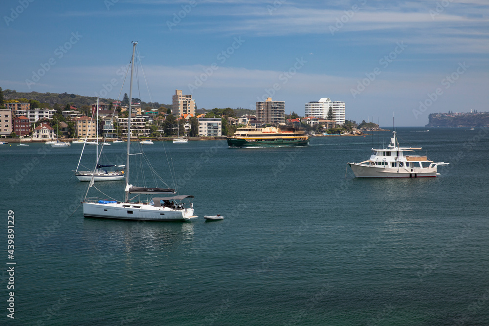 Sailboats and ferry in Manley harbour, Australia