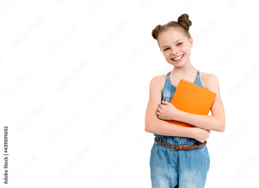 Happy cute smiling child girl in denim overalls holding books. Concept of education, reading, back to school. Happy cute smiling child girl in denim overalls holding books. Concept of education, reading, back to school.