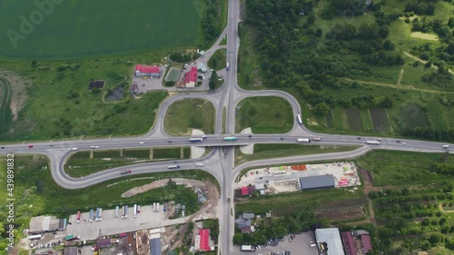 Aerial drone view of highway multi-level junction road with moving cars near to city haos. camera moves back and tilt up The concept of the urban city. Ukraine Vynnyky photo