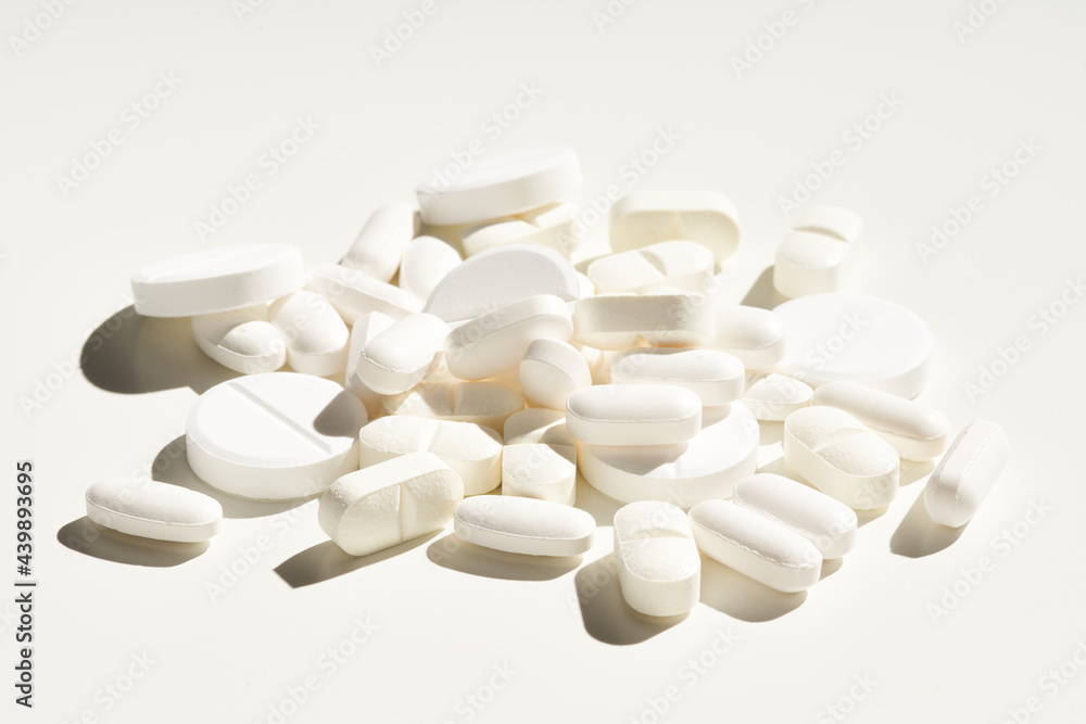 Heap of white medical pills on table Heap of white medical pills on table