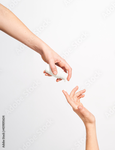 Woman applying cream from pump bottle photo