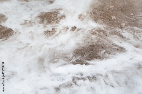 liquid nitrogen spilled on the ground, close-up view of steam photo