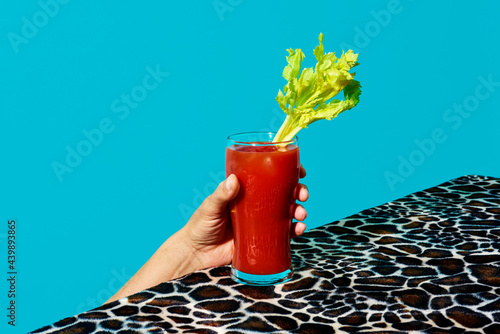 man grabs a glass of bloody mary photo