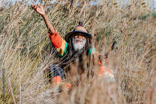 Happy hippie rastaman standing on field photo