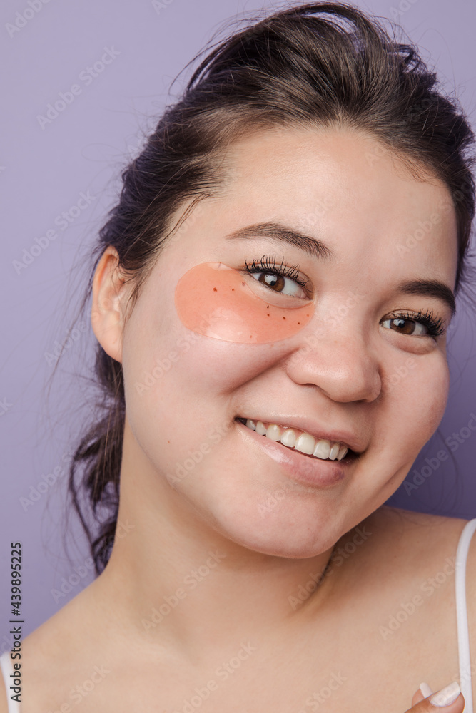 Young brunette east asian woman wearing skincare under eye patch Young brunette east asian woman wearing skincare under eye patch