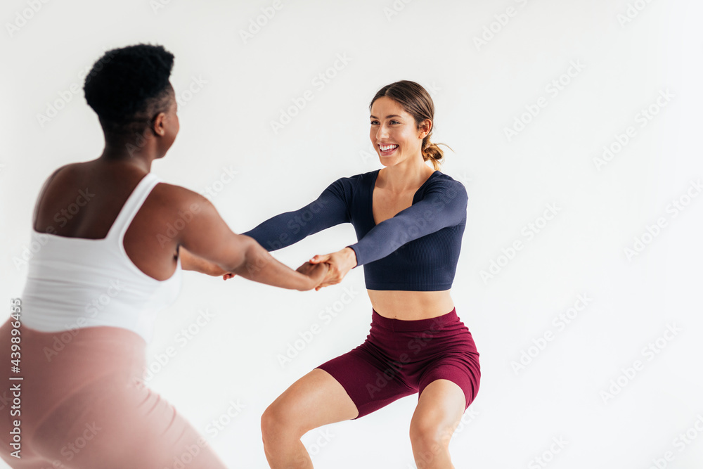 Two Sportswomen Exercising Together in Studio Two Sportswomen Exercising Together in Studio