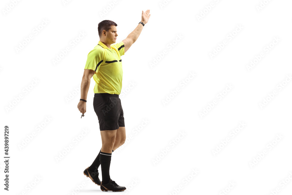 Full length shot of a football referee showing a sign with hand