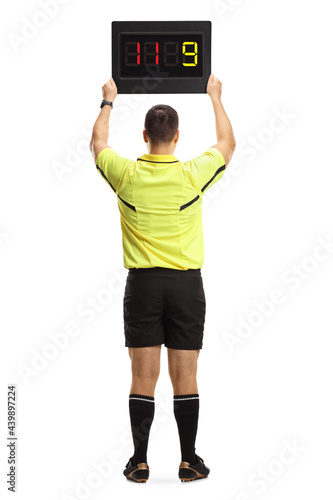 Rear view of a football referee holding a substitute board