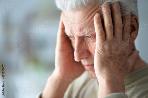 portrait of sad senior man with headache
