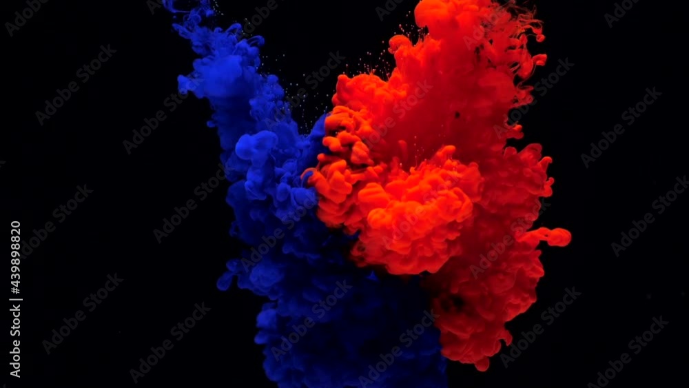 Ink in water. Slow motion blue and red ink drops in water and mixes, swirling softly underwater on black background. Slowmotion acrylic cloud paint in aquarium. Abstract smoke explosion animation