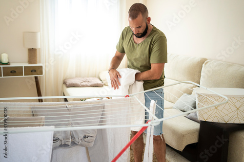 Modern man hanging clothes at home