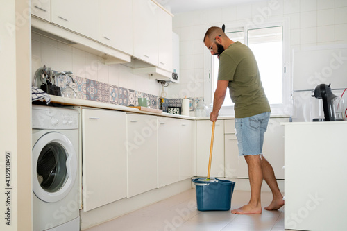 Young man cleaning the floor at home photo