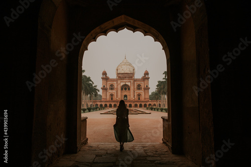 Woman standing in arched passage against Safdarjung Mausoleum photo