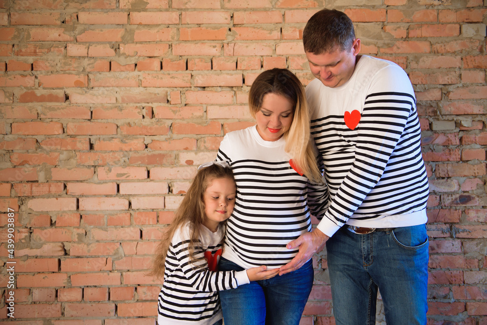 Young pregnant woman with her family, studio shoot