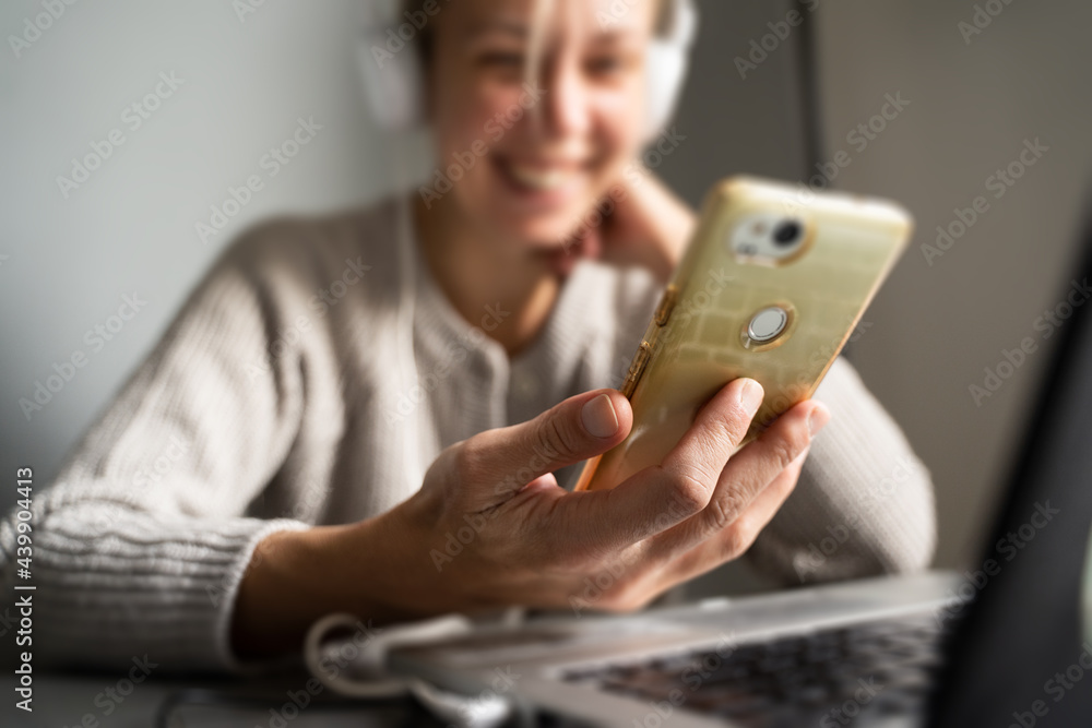 blonde woman laughing while looking at the phone blonde woman laughing while looking at the phone