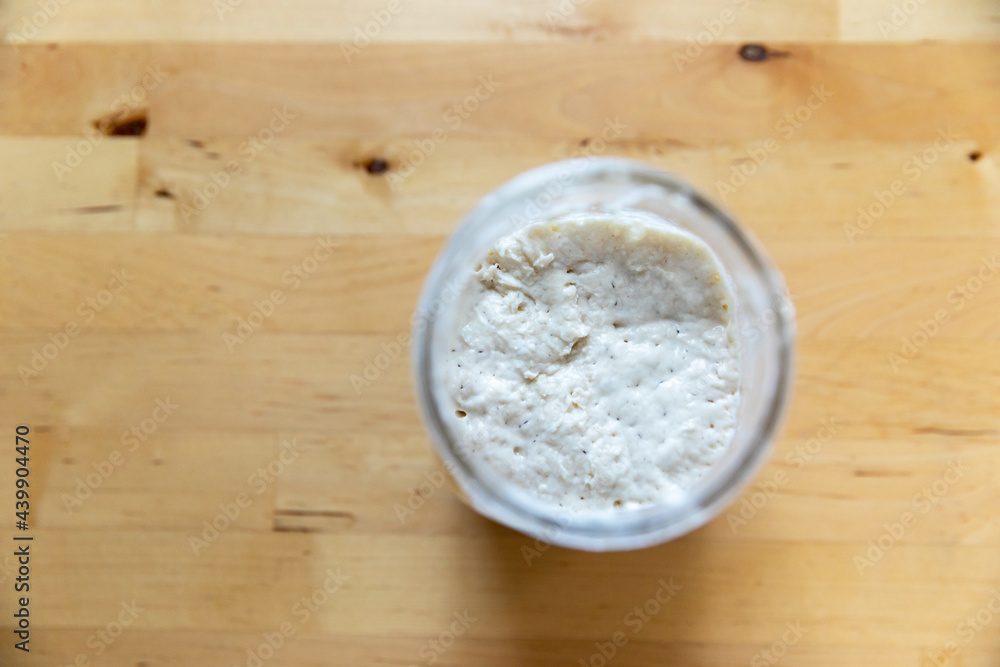 Jar of Sourdough Starter on Wooden Table Jar of Sourdough Starter on Wooden Table