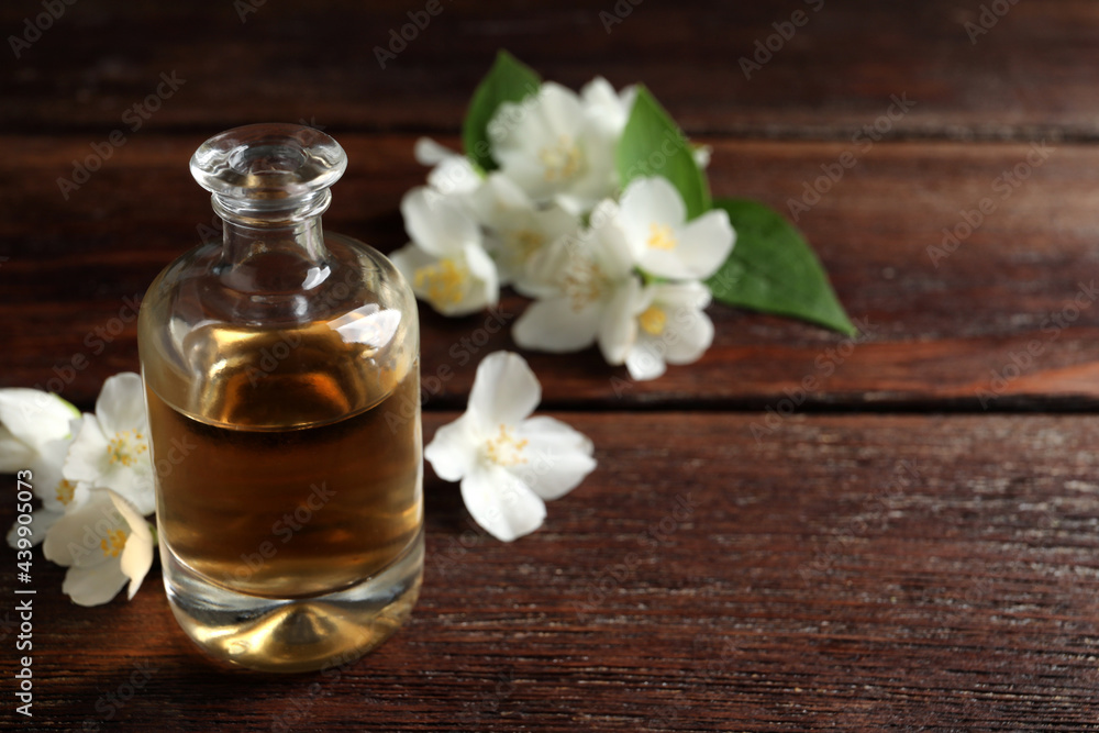 Essential oil and jasmine flowers on wooden table. Space for text Essential oil and jasmine flowers on wooden table. Space for text