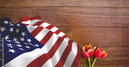 American flag and red tulip flowers on wooden background