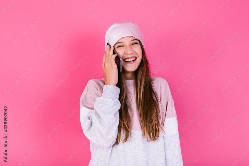 Happy teen talking on smartphone on pink background Happy teen talking on smartphone on pink background