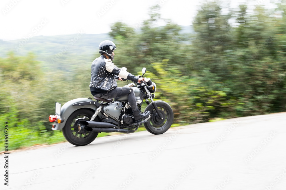 Brutal Hispanic guy riding motorcycle on road in highlands Brutal Hispanic guy riding motorcycle on road in highlands