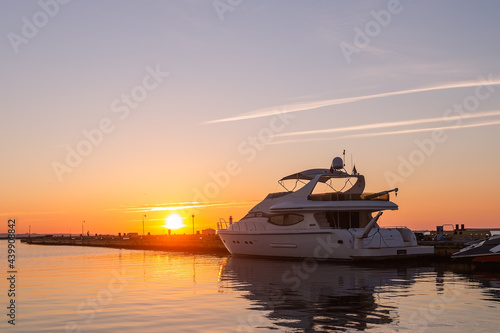 Harbor Elegance: Yacht Club Sunrise with Power Boat © Andrii