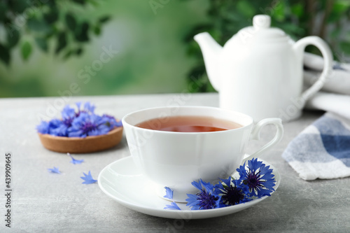 Cup of tea and cornflowers on light table
