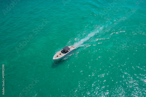 Motor boat top view. Aerial view of a boat in motion turquoise water. Large boat at high speed on turquoise water and top view. Boats top white waves on the water.
