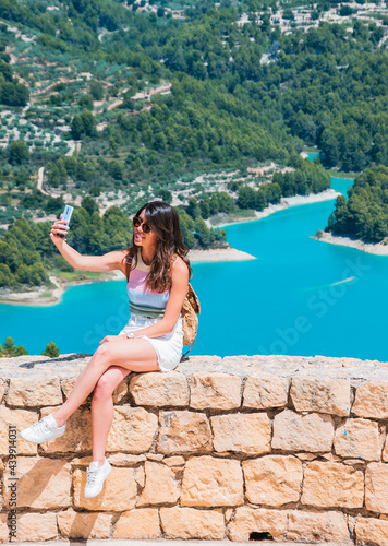 Joven turista tomando fotos desde el mirador en el pantano de Guadalest (Alicante-España)