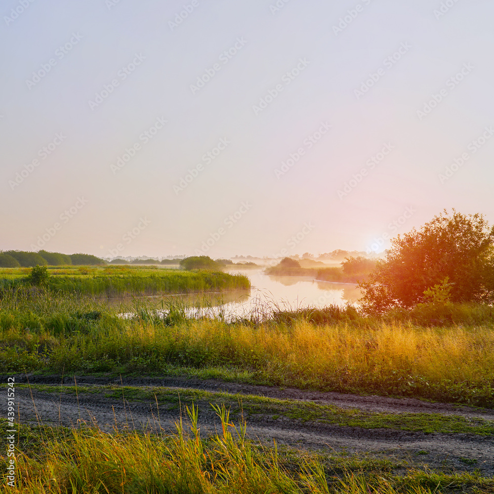 Obraz premium Sunrise in a light fog on a small river