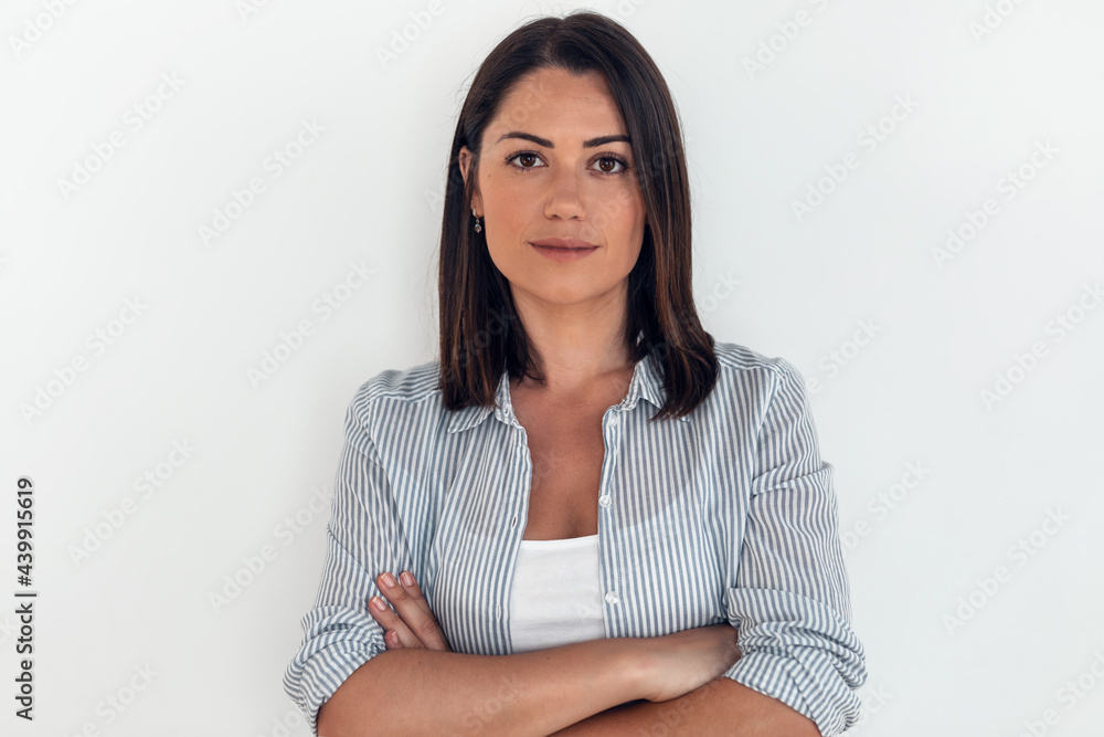 Beautiful young woman looking at camera while standing in the living room at home. Beautiful young woman looking at camera while standing in the living room at home.