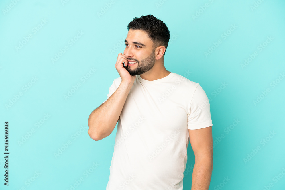 Young arab man isolated on blue background is a little bit nervous Young arab man isolated on blue background is a little bit nervous