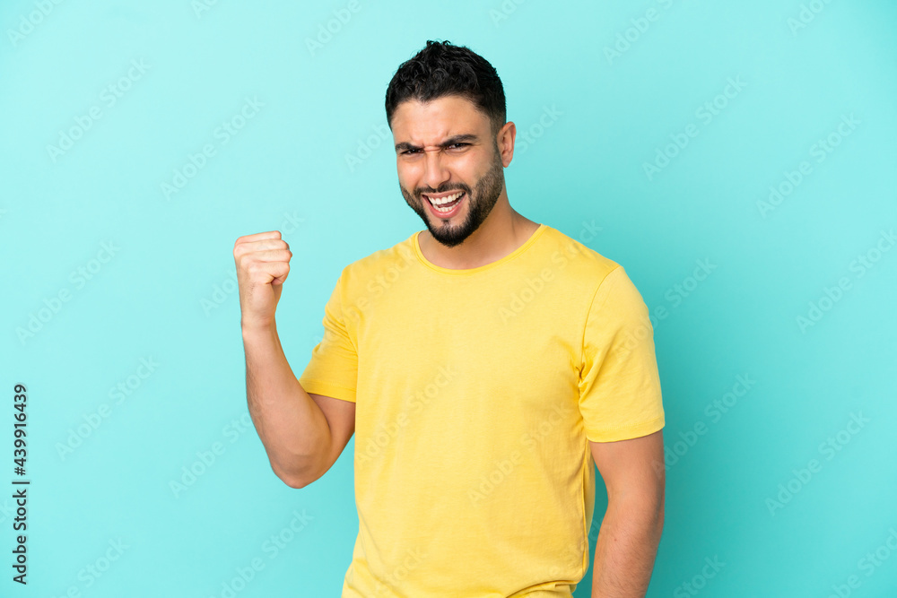 Young arab man isolated on blue background celebrating a victory Young arab man isolated on blue background celebrating a victory