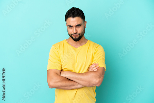 Young arab man isolated on blue background feeling upset