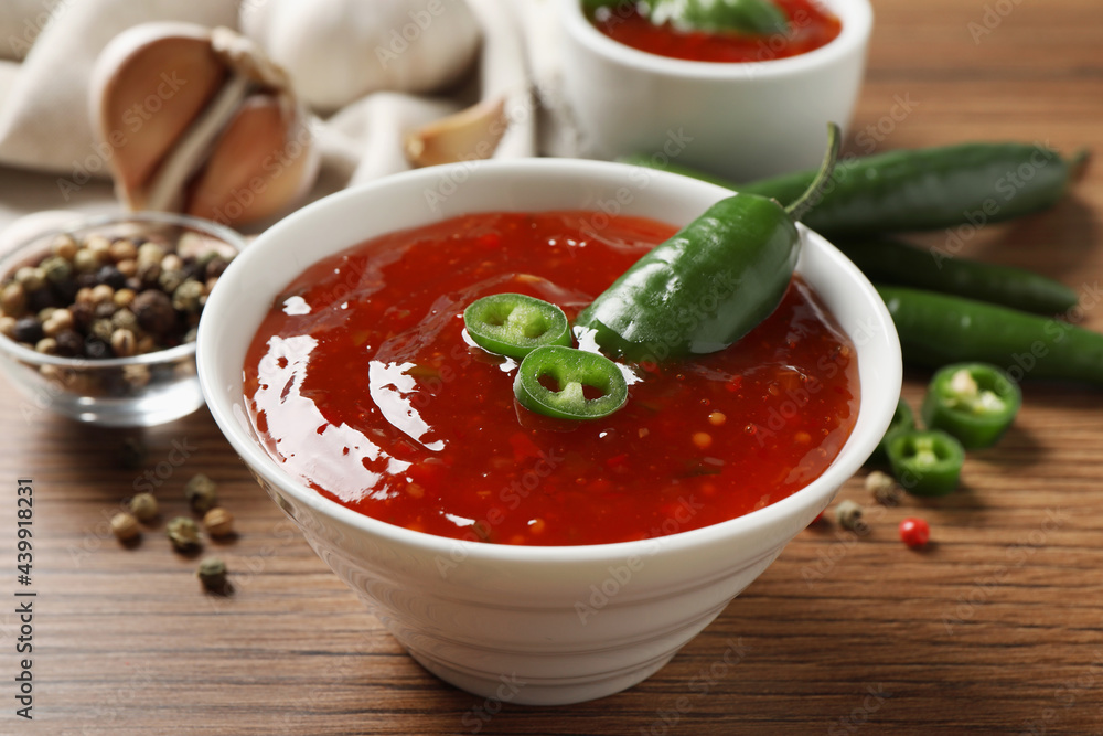 Spicy chili sauce in bowl on wooden table Spicy chili sauce in bowl on wooden table