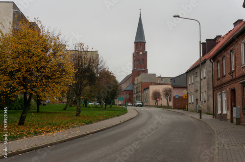 Staszica Street in the autumn overcast day. Tower of Church of the Assumption of the Blessed Virgin Mary in background. Zlocieniec, Poland.