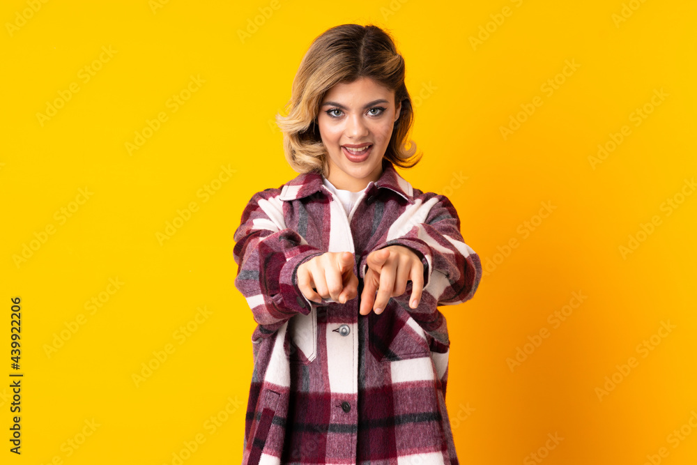 Young Russian woman isolated on yellow background surprised and pointing front Young Russian woman isolated on yellow background surprised and pointing front