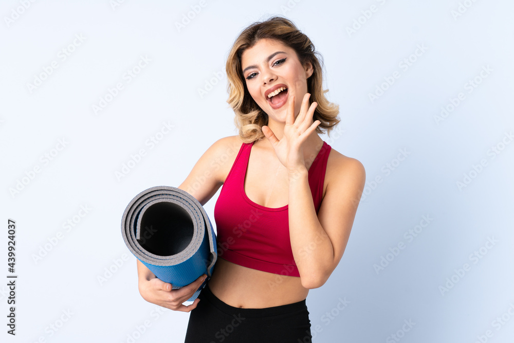 Russian girl with mat isolated on blue background whispering something Russian girl with mat isolated on blue background whispering something