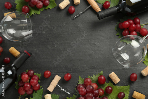 Frame of tasty red wine and grapes on black table  flat lay. Space for text