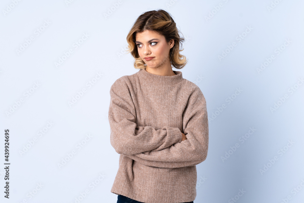 Young Russian woman isolated on blue background keeping the arms crossed Young Russian woman isolated on blue background keeping the arms crossed