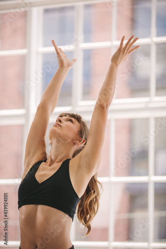 Woman with arms outstretched at yoga class